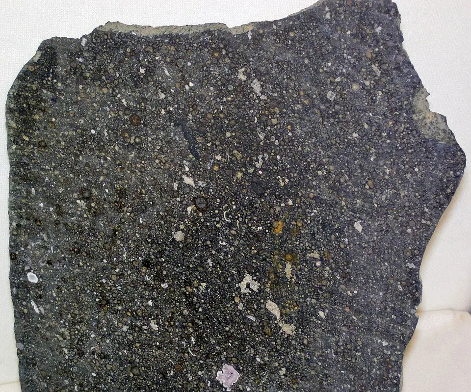 Slice of the Allende meteorite, about 4.56 billion years old. It is a carbonaceous chondrite, a stony meteorite rich in carbon. Maine Mineral and Gem Museum.