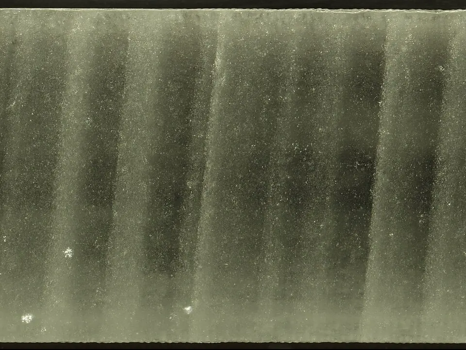 Un tronçon de carotte de glace, un cylindre de glace extrait par forage, prélevé lors du second projet de forage de la calotte du Groenland (GISP2) : les stries claires et sombres sont des couches annuelles. Jusqu’en 1958, les valeurs du CO₂ des 800 000 dernières années ont été mesurées dans l’air ancien piégé dans des carottes semblables, forées en Antarctique.