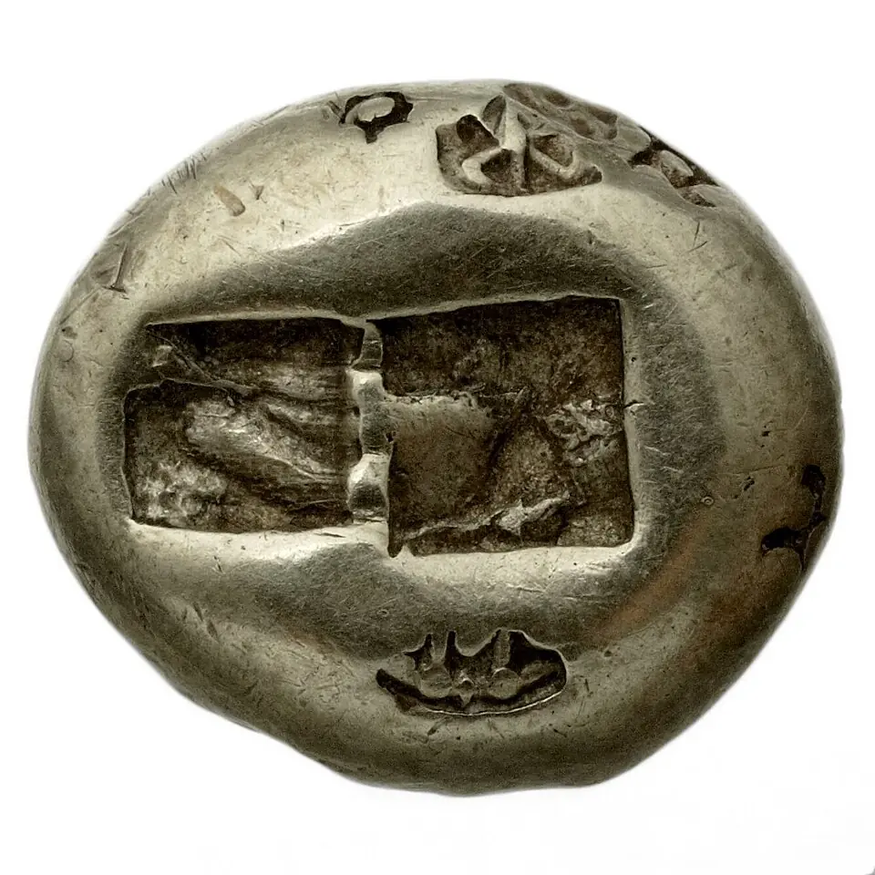 Une tritè, pièce de monnaie en électrum (un alliage d'or et d'argent), frappée à Sardes, en Lydie : le revers, avec les marques laissées par les poinçons. La tritè vaut un tiers de statère, l'unité de ces premières monnaies. Bibliothèque nationale de France.